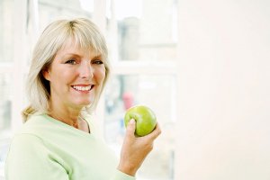 Smiling old lady with apple on hand